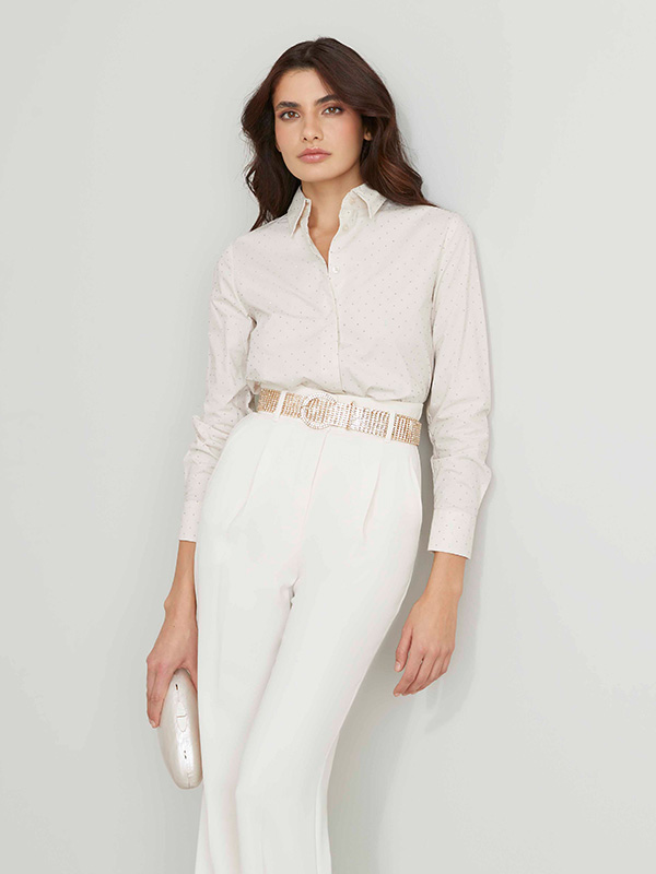 Modella indossa camicia di colore panna abbinati a pantaloni bianchi